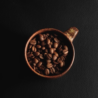 Brown ceramic cup of coffee beans
